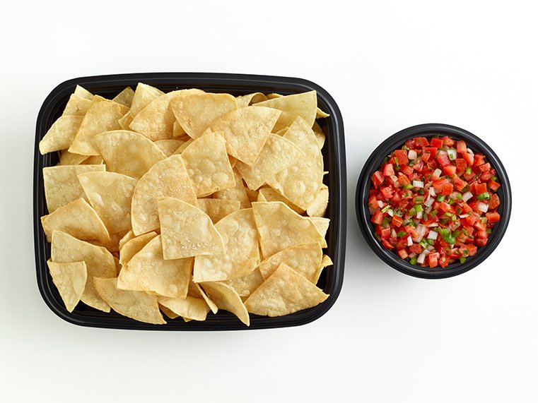 Open catering container of tortilla chips and side of pico de gallo